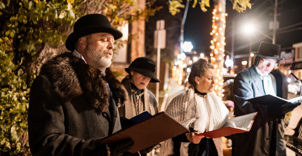 A photograph of a group of people carolling